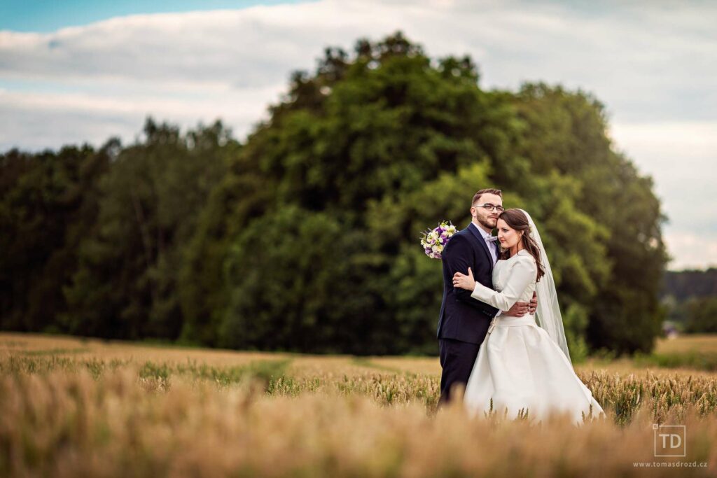 Svatební fotografie ženicha a nevěsty na poli od fotografa Tomáše Drozda